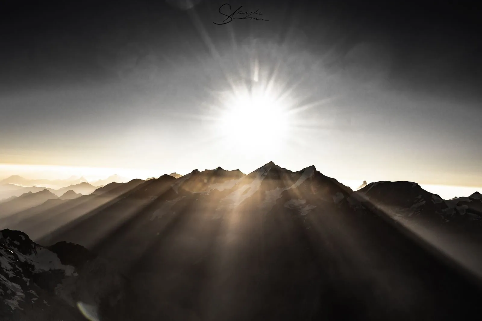 Sonne im Gegenlicht hinter einem dunklen Bergkamm – Mischabelkette